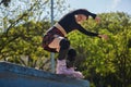 Roller blader female grinding on a ledge in a skatepark. Cool young inline skater person performing a bs full torque slide