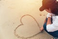 Inlove girl hand drawing heart on sand Royalty Free Stock Photo