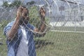 Inmate at barbed wire fence Royalty Free Stock Photo