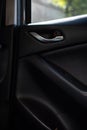 Inner car door handle of a compact SUV modern car, view from an interior of a back seat. Royalty Free Stock Photo