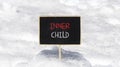 Inner child symbol. Concept words Inner child on beautiful black chalk blackboard. Beautiful white snow background. White snow.