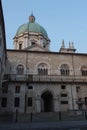 Inner yard of medieval palace Palazzo del Broletto with dome of the New Cathedral on background, Brescia, Lombardy, Italy