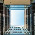 Inner yard of modern office building looking upwards through square opening into blue sky at evening Royalty Free Stock Photo