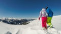 Innerkrems - A couple in colorful skiing outfits and helmets walking on the fresh snow on top of Innerkrems, Austria Royalty Free Stock Photo