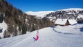 Innerkrems - A snowboarding woman in pink outfit going down the slope in Innerkrems, Austria. There is s snow-capped cottage Royalty Free Stock Photo
