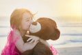 The innocence of childhood. Portrait of a cute little girl playing with her teddy bear on the beach. Royalty Free Stock Photo