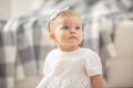 Innocent baby girl looking up with her blue eyes sitting on a floor at home Royalty Free Stock Photo