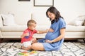 Innocent Boy Touching Abdomen Of Pregnant Mother At Home Royalty Free Stock Photo