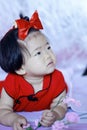 Innocent Chinese little baby in red cheongsam