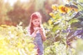 Innocent girl standing by sunflower plants