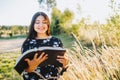 Innocent young religious girl with braces studying the bible, outside in the field at sunset. Spiritual revival