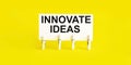 INNOVATE IDEAS , written on white sticky note on yellow background