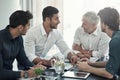 Innovating modern business. a group of businessmen having a meeting around a table in an office. Royalty Free Stock Photo