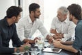 Innovating modern business. a group of businessmen having a meeting around a table in an office. Royalty Free Stock Photo