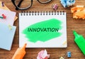 INNOVATION text on a notebook on an office desk, next to it glasses, colorful markers, crumpled sheets and sticky notes Royalty Free Stock Photo