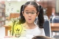 Innovative creative idea for copyrights law concept with girl surprised reading book with lightbulb in library