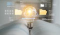 Conceptual representation of digital technology with light bulb symbolizing innovation above open pages and cloud Royalty Free Stock Photo