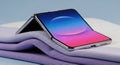 Innovative foldable smartphone displaying vibrant colors on a soft surface Royalty Free Stock Photo