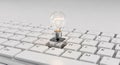 Innovative Idea Generation: Glowing Light Bulb Rests on a White Computer Keyboard for Creative Business Professionals Royalty Free Stock Photo