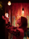 Innovative ideas in dim red light: girl holding a light bulb