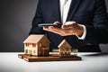 Real estate agent holding a smartphone and a model of a house. Ai generative