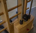 Innovative, special wooden weight stack simulator close up in the gym, different weight, stylish design yellow