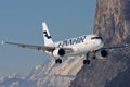 Finnair Airbus A320 landing in Innsbruck in Austria with some mountains around the airport