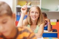 Inquiring minds deserve inspiring answers. Elementary school girl raising her hand in class to ask a question - Royalty Free Stock Photo