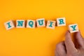 INQUIRY. Wooden blocks with letters on a yellow background