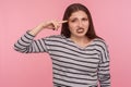 Insane idea! Portrait of displeased woman in striped sweatshirt showing stupid gesture, accusing dumb suggestion