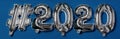 The inscription of the air inflatable foil balloon glossy hashtag letters 2020 on a blue background