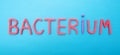 The inscription bacterium from red letters on a blue background, the concept of the development and evolution of bacteria in