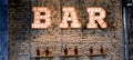 Inscription Bar of light bulbs against the wall of bricks Royalty Free Stock Photo