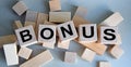 The inscription BONUS on wooden cubes isolated on a light background, the concept of business and finance