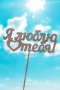 the inscription carved in wood in Russian I love you against the sky