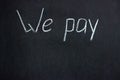 The inscription on the chalkboard `We pay`. A common phrase in business and finance