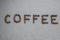 The inscription Coffee is lined with coffee beans. Rough grey stone background Royalty Free Stock Photo