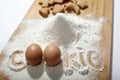 Inscription `cookies` with flour and eggs on a bamboo cutting board