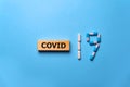Inscription COVID-19 with pills on blue background. World Health Organization WHO introduced new official name for Coronavirus