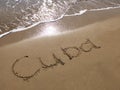 Inscription Cuba on the sandy beach and foamy sea water Royalty Free Stock Photo