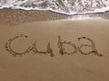 Inscription Cuba on the sandy beach and foamy sea water Royalty Free Stock Photo