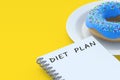 Inscription diet plan on notepad near donut on plate
