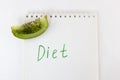 Inscription diets on a notepad and a slice of kiwi on a white background dieting