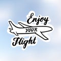 The inscription: `Enjoy your Flight`, with image airplane, drawn in black ink on a realistic blue sky.