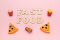 The inscription fast food, pizza slices, popcorn and French fries on a pink background Royalty Free Stock Photo