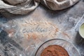 The inscription flour `Cooking` on a gray wooden messy background. Flour mixture, eggs and sunflower oil. Cozy culinary cover, con