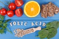 Inscription folic acid with healthy nutritious food as source minerals, vitamin B9 and dietary fiber Royalty Free Stock Photo