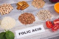 Inscription folic acid with various products or ingredients as source natural vitamin B9 and minerals Royalty Free Stock Photo