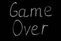 Inscription game over in white chalk on a rough black board Royalty Free Stock Photo