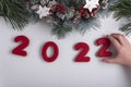 Inscription 2022 from gingerbread cookie, child hand taking cookie. New Year and Christmas decor Royalty Free Stock Photo